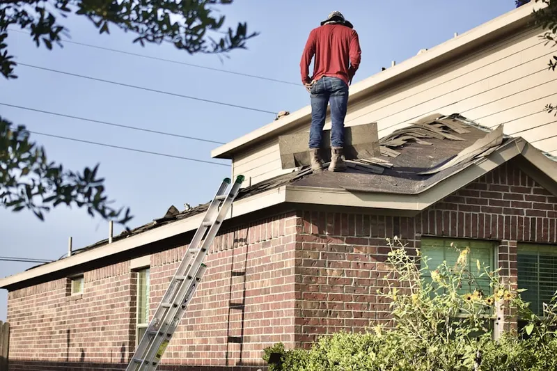 Professional roofer working on a residential roof in Willington